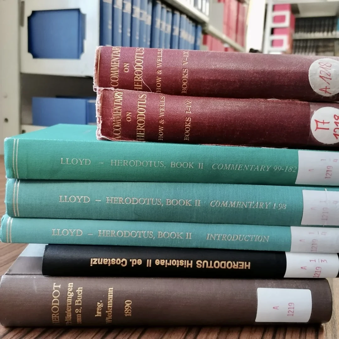 Eine Wissenschaftlerin und ein Wissenschaftler arbeiten hinter einer Glasfassade und mischen Chemikalien mit Großgeräten.